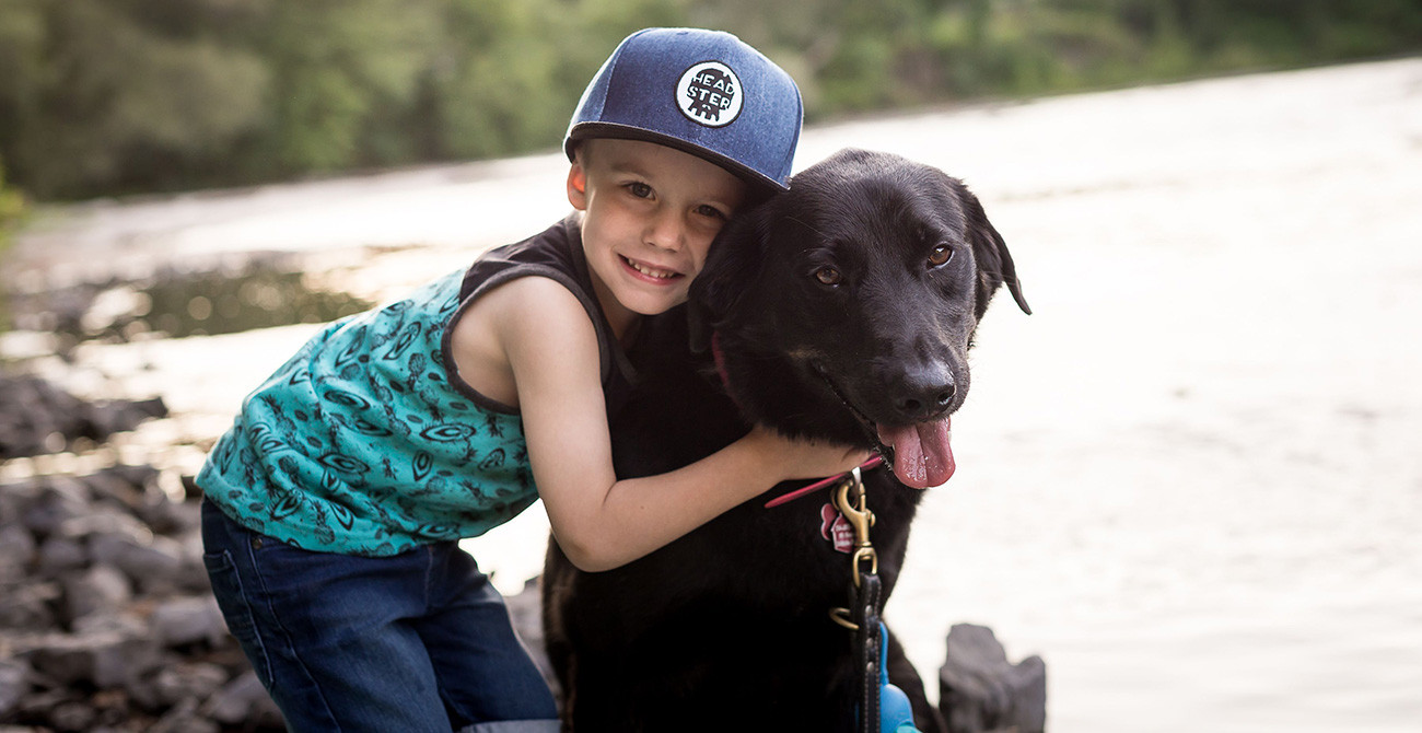 Enfant qui donne un câlin à un chien