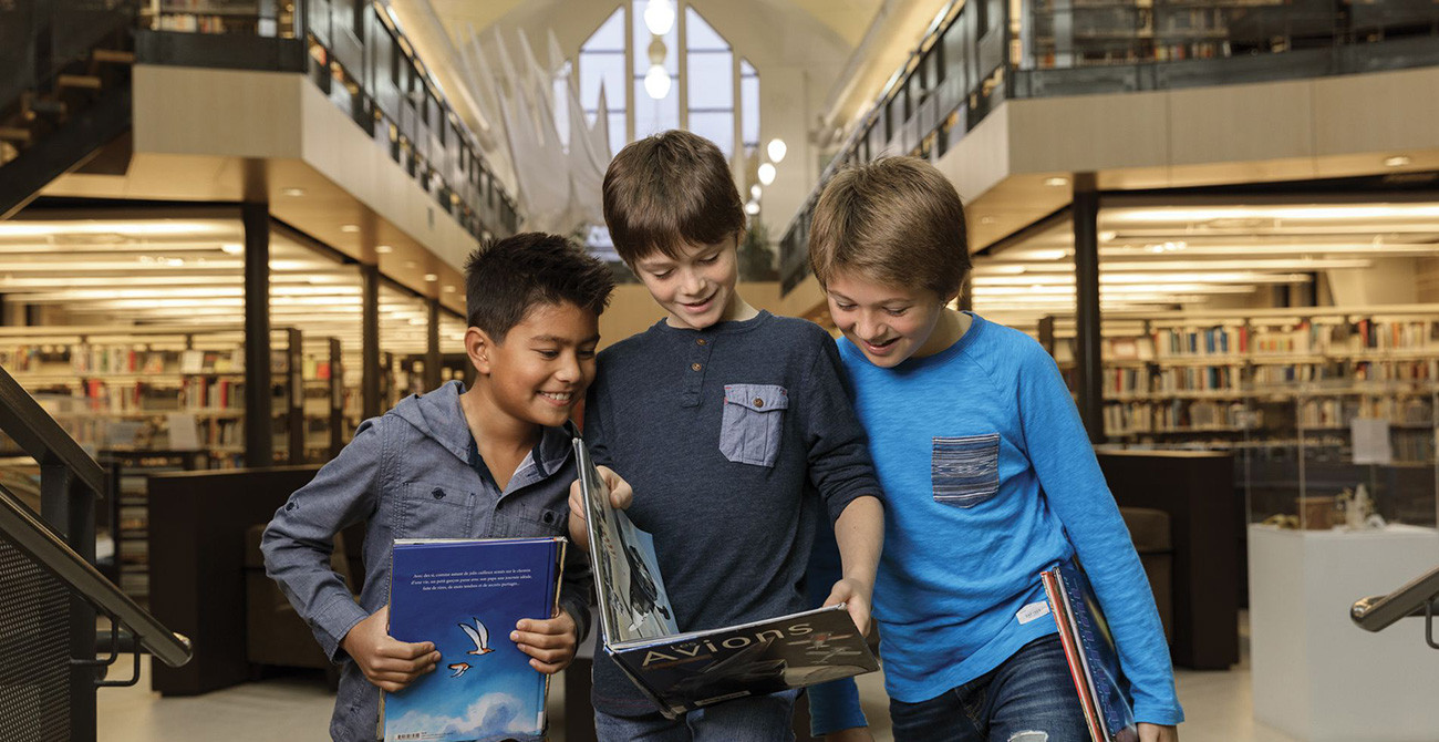 3 enfants qui regardent un livre